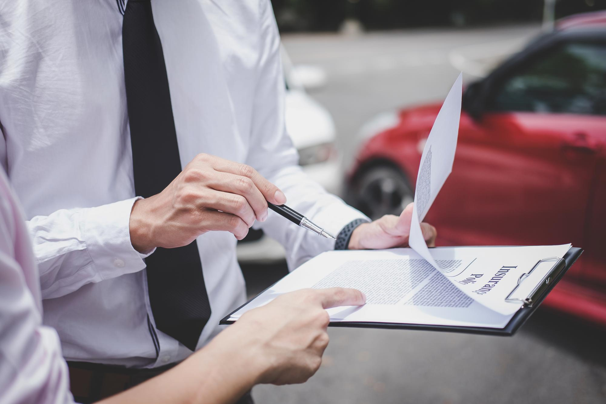 Agent reviewing vehicle licensing paperwork on a clipboard
